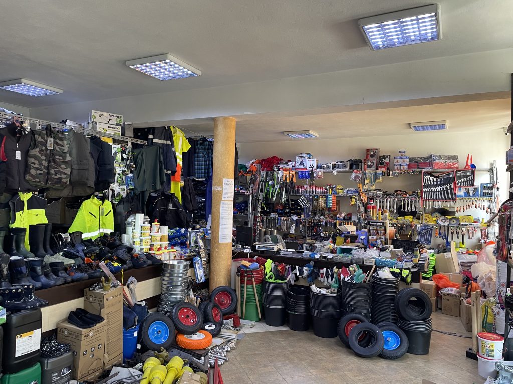 Wnętrze sklepu Agromarket z szerokim wyborem odzieży roboczej, obuwia BHP, środków chemicznych i akcesoriów rolniczych.