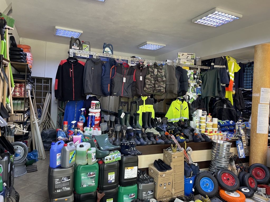 Wnętrze sklepu Agromarket z szerokim wyborem odzieży roboczej, obuwia BHP, środków chemicznych i akcesoriów rolniczych.
